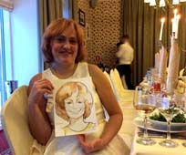 Марина позирует художнику на юбилее шаржист Мишель, шаржист Михаил Шабалин